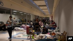 Kikundi cha wakimbizi kituo cha duka la Tesco, kilichopo mpakani kati ya mji wa Medyka, na Przemysl, Poland, Ijumaa, Macih 4, 2022 kilichogeuzwa kuwa ni mahali pa Wakimbizi waliofanikiwa kuondoka Ukraine kupumzika. I (AP Photo/Marc Sanye)