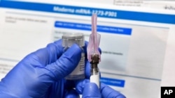 FILE - In this July 27, 2020 photo, a nurse prepares a syringe during a study of a possible COVID-19 vaccine in Binghamton, N.Y.
