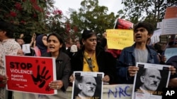 Indians holds placards during a protest against a new citizenship law out side Gandhi Ashram in Ahmadabad, India, Tuesday, Dec. 17, 2019. 