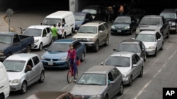 Vehículos hacen fila cerca de una estación de servicio para llenar sus tanques, en Caracas, Venezuela. El precio internacional fue establecido en 0.50 centavos de dólar por litro.
