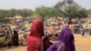 Des filles soudanaises qui ont fui le conflit dans la région soudanaise du Darfour et qui étaient auparavant déplacées à l'intérieur du Soudan, regardent des abris de fortune près de la frontière entre le Soudan et le Tchad, le 13 mai 2023.