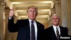 U.S. President Donald Trump gives a thumbs-up as he and Vice President Mike Pence depart the U.S. Capitol after a meeting to discuss tax legislation with House Republicans, Nov. 16, 2017. 