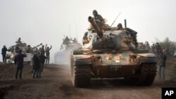 Turkish army tanks enter Afrin, an area in northern Syria controlled by U.S.-allied Kurdish fighters, in Hassa, Hatay, Turkey, January 22, 2018. (AP Photo)