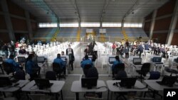 Los pacientes esperan recibir su inyección de la vacuna Sinovac COVID-19 de China durante un programa de vacunación prioritaria para personas mayores en Bogotá, Colombia, el martes 9 de marzo de 2021.