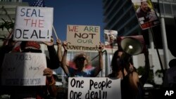 Familiares y partidarios de rehenes israelíes retenidos por Hamás en Gaza sostienen carteles y banderas durante una protesta que pide el regreso de los cautivos, el 11 de junio en Tel Avid.