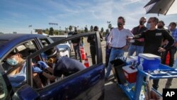 ARHIVA - Gradonačelnik Los Anđelesa Erik Garseti (D) i guverner Kalifornije Gevin Njusom (L) prate vakcinaciju protiv koronavirusa na stadionu u Los Anđelesu (Foto: AP)