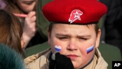 Викрадені та перетворені на зброю тисячі молодих українців тепер воюють проти своєї батьківщини, кажуть експерти. На фото член «Юнармії» під час святкування 9-ї річниці анексії Криму від України. Санкт-Петербург, Росія, 18 березня 2023 року. (AP)