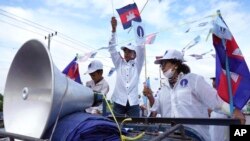 រូបឯកសារ៖ អ្នក​គាំទ្រ​គណបក្ស​ភ្លើងទៀន​​ឈរ​លើ​រថយន្ត​ពេល​ដើរ​ដង្ហែ​ក្នុង​ពេល​យុទ្ធនាការ​ឃោសនា​បោះ​ឆ្នោត​ឃុំ​សង្កាត់​ថ្ងៃ​ទី​៥ ខែ​មិថុនា នៅ​រាជធានី​ភ្នំពេញ ប្រទេស​កម្ពុជា កាល​ពី​ថ្ងៃ​សៅរ៍ ទី២១ ខែ​ឧសភា ឆ្នាំ​២០២២។ 