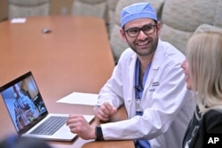 Dr. Rohaid Ali plays a video from a high school project made by his patient Alexis Bogan on Thursday, March 11, 2024, at Rhode Island Hospital in Providence, R.I. (AP Photo/Josh Reynolds)