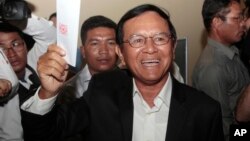 Opposition Cambodia National Rescue Party President Kem Sokha shows off his ballot before voting in local elections in Chak Angre Leu on the outskirts of Phnom Penh, Cambodia, Sunday, June 4, 2017. 