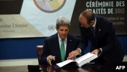 AQSh Davlat kotibi Jon Kerri Xalqaro qurol-yarog' bitimiga qo'l qo'ymoqda, Nyu-York, 25-sentabr, 2013-yil.