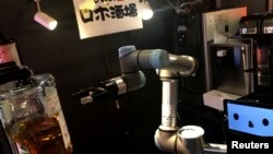 A robot bartender moves its arm to make a cocktail at Japanese style bar Izakaya chain "Yoronotaki" in Tokyo, Japan January 29, 2020. Picture taken on January 29, 2020. REUTERS/Tim Kelly
