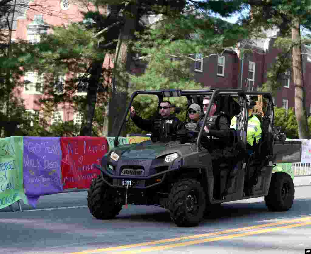 A State Police Special Response team patrols past posters of encouragement at Wellesley College before the start of the 118th Boston Marathon, Wellesley, Mass., April 21, 2014.