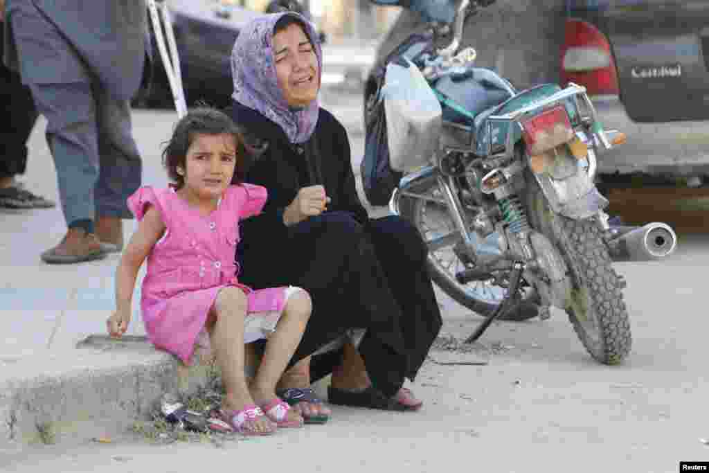 A woman and a girl react after, according to activists, two barrel bombs were thrown by forces loyal to &nbsp;President Bashar Al-Assad, in Hullok neighborhood, Aleppo, May 1, 2014.&nbsp;