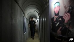 20 جولائی 2016 کو غزہ سٹی میں حماس کے زیر انتظام یوتھ سمر کیمپ میں ہتھیاروں کی نمائش کے دوران ایک فلسطینی نوجوان فوجی مشقوں کے لیے استعمال ہونے والی سرنگ کے اندر، فوٹو اے پی
