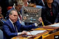 Duta Besar Israel untuk PBB, Gilad Erdan, berbicara sambil memegang properti saat pertemuan Dewan Keamanan PBB, 23 Januari 2024. (Foto: AP)