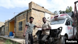 FILE - Eritrean nationals Goitom Tesfaye, 24, left, and Filimon Daniel, 23, are pictured at their garage in Mekele, Tigray region, Ethiopia, July 7, 2019.
