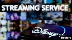 FILE PHOTO: A smartphone screen showing the "Disney+" logo is seen in front of the words "streaming service" in this illustration