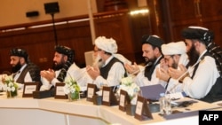 FILE - Members of the Taliban attend the second day of the Intra Afghan Dialogue talks in the Qatari capital, Doha, July 8, 2019. 