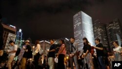 Attendees hold candles in a vigil for the fourth apparent suicide related to the protests against an extradition law to China, in Hong Kong, July 10, 2019.