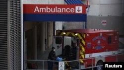 A healthcare worker places a stretcher inside of an ambulance at the emergency room entrance of Houston Methodist Hospital in the Texas Medical Center as cases of the coronavirus disease (COVID-19) spike in Houston, Texas, U.S., July 8, 2020. 