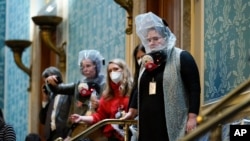 People are seen in the House gallery as protesters try to break into the House Chamber at the U.S. Capitol on Wednesday, Jan. 6, 2021, in Washington. (AP Photo/Andrew Harnik)