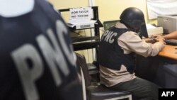 En la foto de archivo agentes de la Policia Nacional Civil (PNC), fichan en la Torre de Tribunales a uno de sus cuatro compañeros, entre ellos el jefe de la seccion contra el crimen organizado.