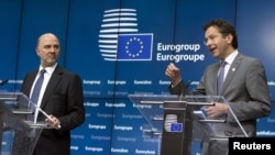 European Economic and Monetary Affairs Commissioner Pierre Moscovici (L) and Eurogroup President Jeroen Dijsselbloem speak at a news conference after a eurozone finance ministers emergency meeting on Greece in Brussels, Belgium, June 22, 2015. 