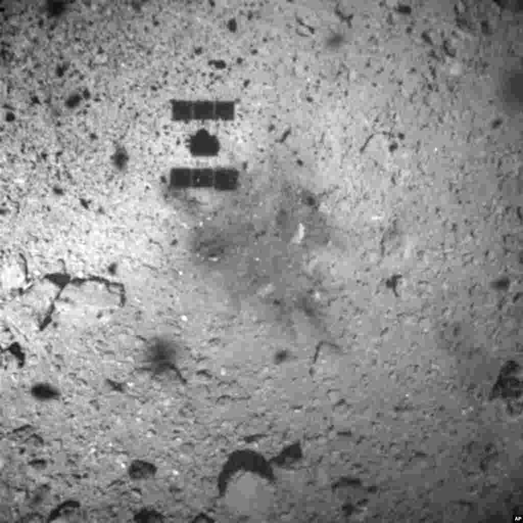FILE - In this Feb. 22, 2019, file photo, this image released by the Japan Aerospace Exploration Agency (JAXA) shows the shadow, center above, of the Hayabusa2 spacecraft after its successful touchdown on the asteroid Ryugu.