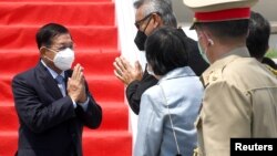 Myanmar's junta chief Senior General Min Aung Hlaing (L) gestures as he is welcomed upon his arrival ahead of the ASEAN leaders' summit, at the Soekarno Hatta International airport in Tangerang, on the outskirts of Jakarta, Indonesia, April 24, 2021. Cour