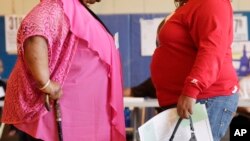 FILE - Two women converse in New York. New government figures released Friday, Oct. 13, 2017 showed small increases that were not considered statistically significant but were seen by some as a cause for concern. The adult obesity rate rose from to about 