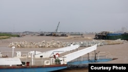 កន្លែង​ចាក់​ថ្ម​ចូល​ទឹក​ទន្លេ​ក្នុង​ភូមិសាស្រ្ត​អរិយក្សត្រ មើល​ពី​ចំណត​សាឡាង ដែល​ស្ថិត​នៅ​ក្រោម​គម្រោង​របស់​ក្រុមហ៊ុន ឃុន សៀ ​ថ្ងៃ​ទី៧ ខែកក្កដា ឆ្នាំ២០២១។ (រូបថត​ផ្តល់ឲ្យ​ដោយ ព្រីង សំរាំង)