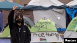 FILE - Student protest organizer, Steph W. raises her right fist as she poses for a portrait at an encampment in support of Palestinians in Gaza at the Auraria Campus in Denver, Colorado, U.S., May 10, 2024. (REUTERS/Kevin Mohatt)