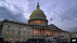 FILE - Dusk falls as Congressional leaders work, at the Capitol in Washington, Dec. 21, 2020.