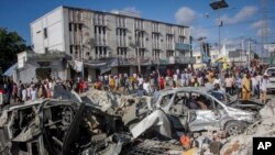 Watu wakiangalia uharibifu uliofanywa na magari mawili yaliyokuwa yametegwa mabomu kwenye makutano yenye shughuli nyingi huko Mogadishu, Somalia, Jumapili, Oktoba 30, 2022. (AP)
