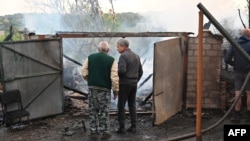Ljudi pregledaju ostatke svoje uništene kuće nakon napada ruskih dronova u predgrađu Harkova, 21. maja 2024.