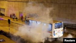 Un autobús envuelto en gases lacrimógenos lanzados por la policía contra manifestantes en Lima, Perú, el 13 de diciembre de 2022.