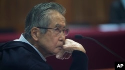 ARCHIVO - El expresidente peruano Alberto Fujimori, fotografiado a través de una ventana, enfrenta un juicio en una estación policial en las afueras de Lima, Perú, el 28 de junio de 2016. 