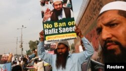 جماعت الدعوۃ کا ایک حامی جماعت کے سربراہ حافظ سعید کے حق میں ہونے والے مظاہرے میں شریک ہے۔ (فائل فوٹو)