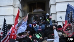 Abanywanyi ba Perezida Trump bahangana n'igiporisi hamwe n'abajejwe umutekano igihe batera inyubako ya Kongre i Washington, italiki 06/01/2021.