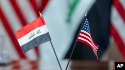 ARCHIVO - Las banderas de Irak y de Estados Unidos yacen sobre una mesa durante una reunión entre el secretario de Defensa estadounidense Lloyd Austin y el ministro de Defensa iraquí, Muhammad Al-Abbasi, el martes 23 de julio de 2024, en el Pentágono, en Washington. 