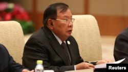 FILE - Laos' President Bounnhang Vorachith speaks with Chinese President Xi Jinping (not pictured) during a bilateral meeting at Diaoyutai State Guesthouse in Beijing, China.