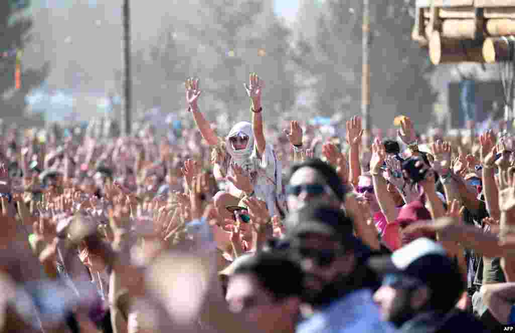 People watch the start of the solar eclipse and raise their hands in prayer in an eclipse viewing event led by Native American elders, at Big Summit Prairie ranch in Oregon's Ochoco National Forest near the city of Mitchell, Aug. 21, 2017.