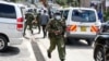 Un policier kenyan tenant une bombe lacrymogène a couru lors de manifestations à Nairobi, au Kenya, le jeudi 13 mai 2021.