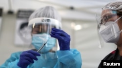 រូបឯកសារ៖ បុគ្គលិកសុខភិបាលកំពុងរៀបចំការចាក់វ៉ាក់សាំងបង្ការជំងឺកូវីដ១៩ របស់ក្រុមហ៊ុន Pfizer-BioNTech នៅទីក្រុង Los Angeles រដ្ឋកាលីហ្វ័រញ៉ា កាលពីថ្ងៃទី៧ ខែមករា ឆ្នាំ២០២១។