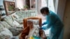 FILE - Nurse Pilar Rodríguez administers the COVID-19 vaccine to her patient, Antonia Crespi Gomila, 93, at her home in Sa Pobla, Mallorca, Spain, April 30, 2021.