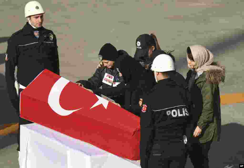 Family members attend a memorial for police officers killed outside the Besiktas football club stadium Vodafone Arena, in Istanbul, Dec. 11, 2016.