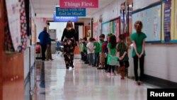 Students stand 2 feet apart as they practice social distancing before walking into the cafeteria on the first day back to school after coronavirus disease (COVID-19) restrictions were adjusted, in Louisville, Kentucky, U.S. March 17, 2021. REUTERS/Amira 