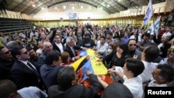 Familiares y amigos rodean el féretro de Fernando Villavicencio durante su sepelio en el Centro de Exposiciones de Quito, el 11 de agosto de 2023.