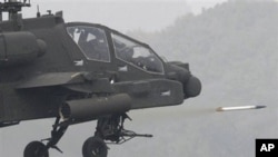 US Apache helicopter fires rocket during joint military exercise between South Korea and United States at US firing Rodriguez Range in Pocheon, south of the demilitarized zone that divides two Koreas, 13 Oct. 2010.
